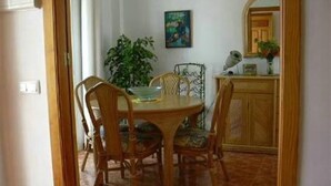 A dining area with a wooden table, four chairs, a potted plant, and a cabinet. - Villa "Casa Galesa" with Outdoor Pool (Nerja)