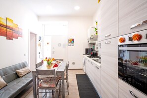 Une cuisine moderne avec un coin repas, un canapé et une vue sur le salon.