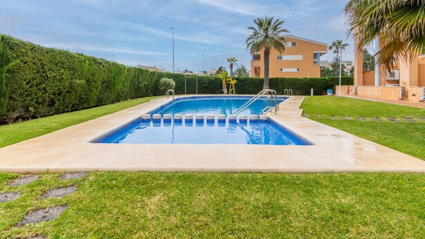 A rectangular swimming pool with a clear blue water, surrounded by a concrete deck. - Pet-Friendly Apartment 'Edificio Menorca' close to the Sea with Shared Pool & Wi-Fi (Alicante)