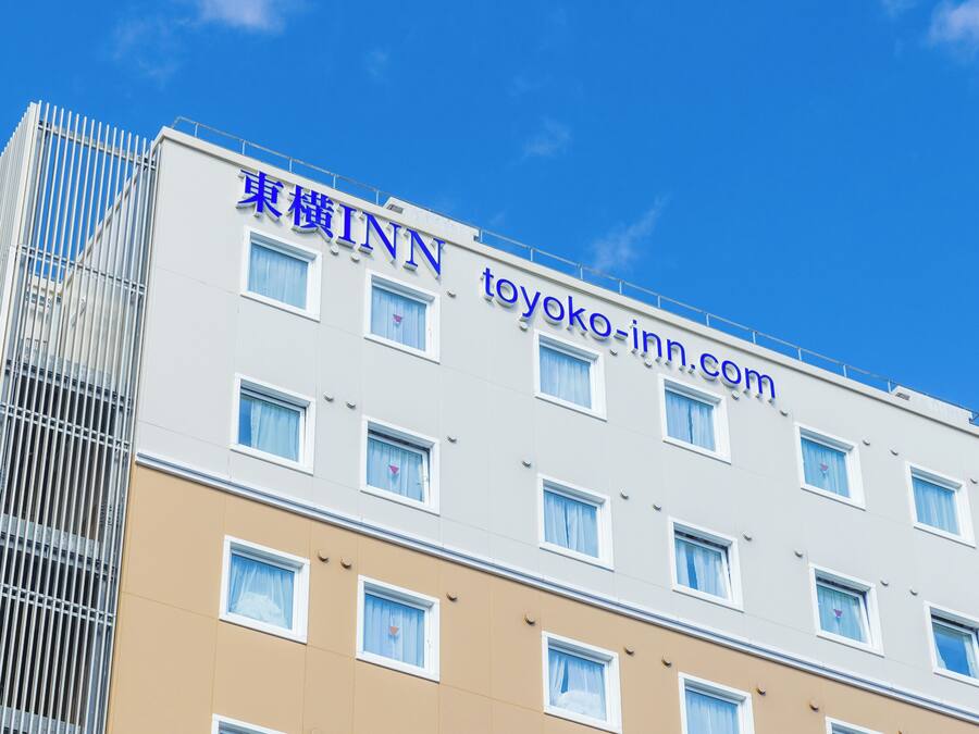 A multi-story building with a sign reading "TOYOKO INN" and the website "toyoko-inn.com".