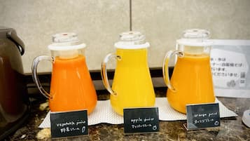 Three pitchers of juice with labels indicating vegetable, apple, and orange juice.