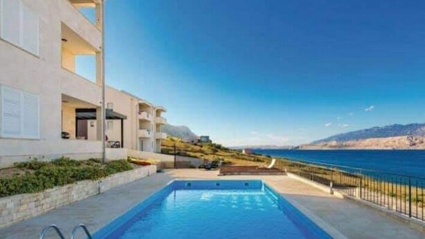 Un edificio moderno con piscina y vista al mar.
