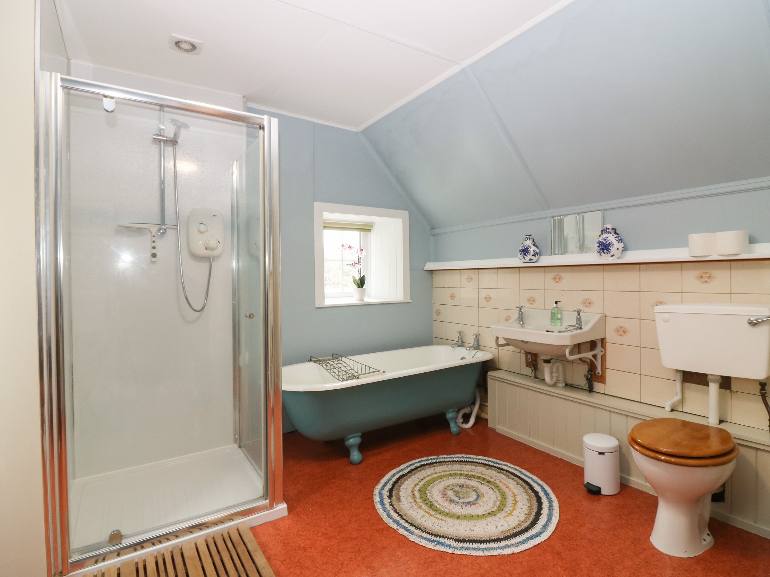 Un baño con ducha de vidrio, bañera independiente, lavamanos y retrete.