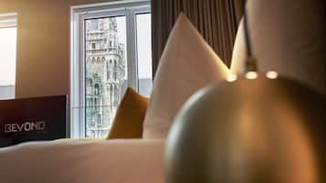 A hotel room with a bed, a view of a historic building through a window, and a sign reading "BEYOND".