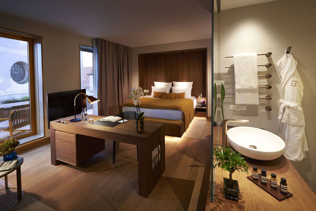 Et moderne hotelværelse med seng, skrivebord og badeværelse.