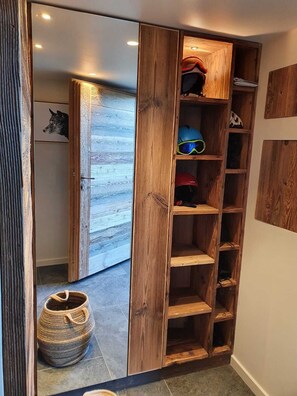 A wooden shelving unit with various items, including helmets and a woven basket.
