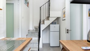 Eine moderne Küche mit Marmorarbeitsplatte, Einbauofen und Kühlschrank.