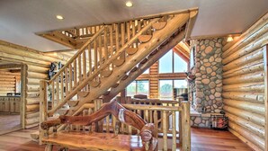 A wooden staircase with a unique design, leading to a stone wall and a window.