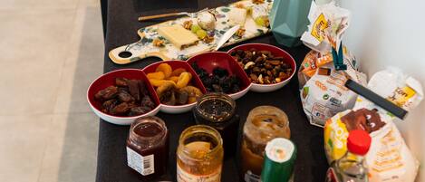 A buffet table with various food items, condiments, and a toaster.