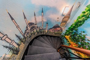 A spiral staircase with a mural of a mosque and minaret.