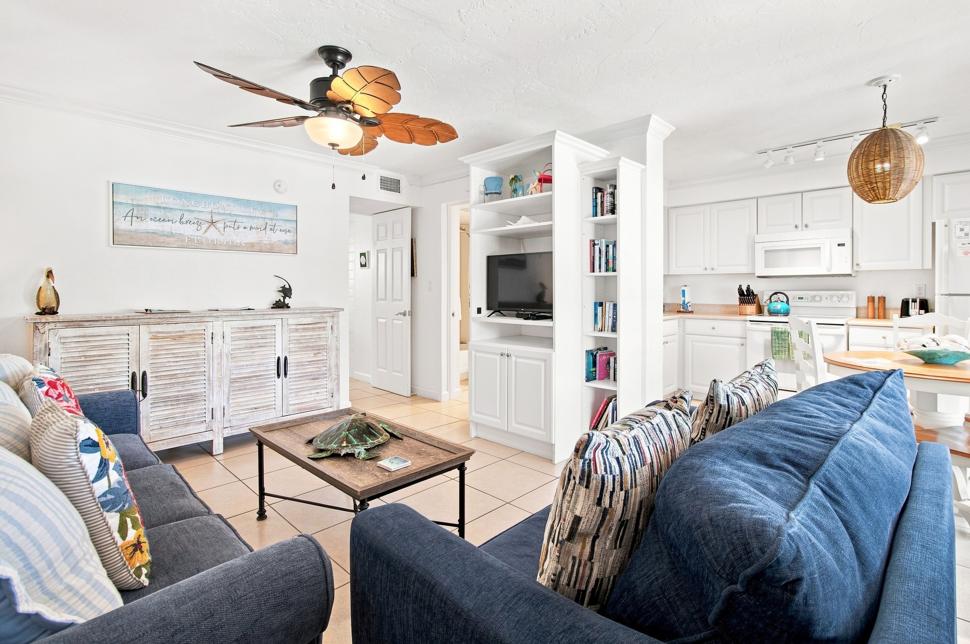 A modern living room with a sofa, coffee table, and a ceiling fan.