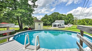A wooden deck surrounding a clear blue swimming pool with a small shed and a garage in the background. - Ocean Inlet Cottage w/ Deck & Grill! (West, Bath)