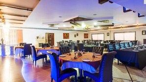 Une salle de conférence dotée de plusieurs tables et chaises, ainsi que de plaques nominatives et de microphones.