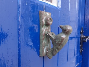 A blue door with a rustic metal handle featuring a fish design. - Inviting 3-bed Cottage Close to Pwllheli (Pwllheli)