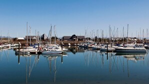 A marina with multiple boats docked, calm water, and a building in the background. - Inviting 3-bed Cottage Close to Pwllheli (Pwllheli)