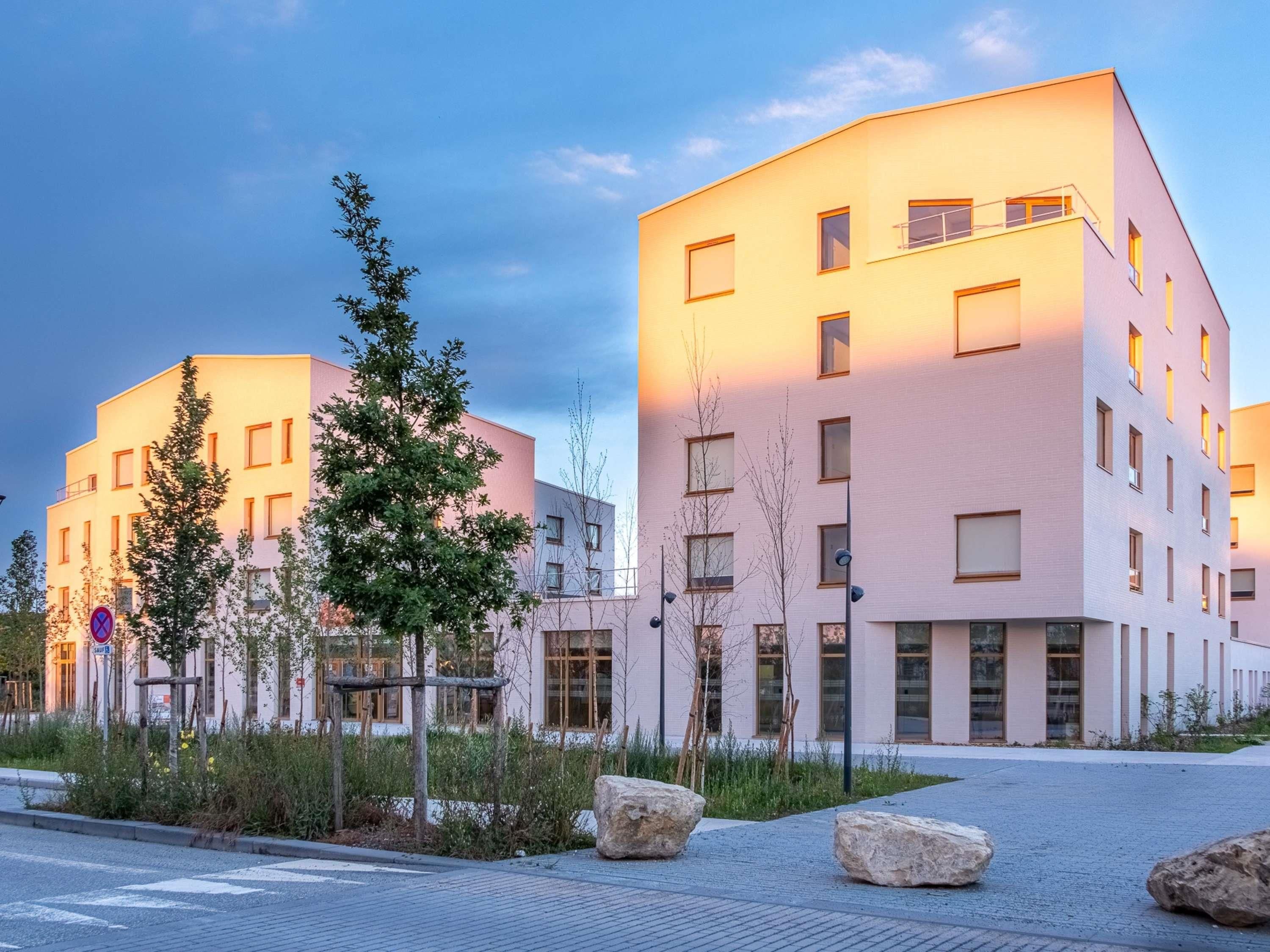 Un bâtiment moderne à plusieurs étages, doté de grandes fenêtres et d’un toit plat.