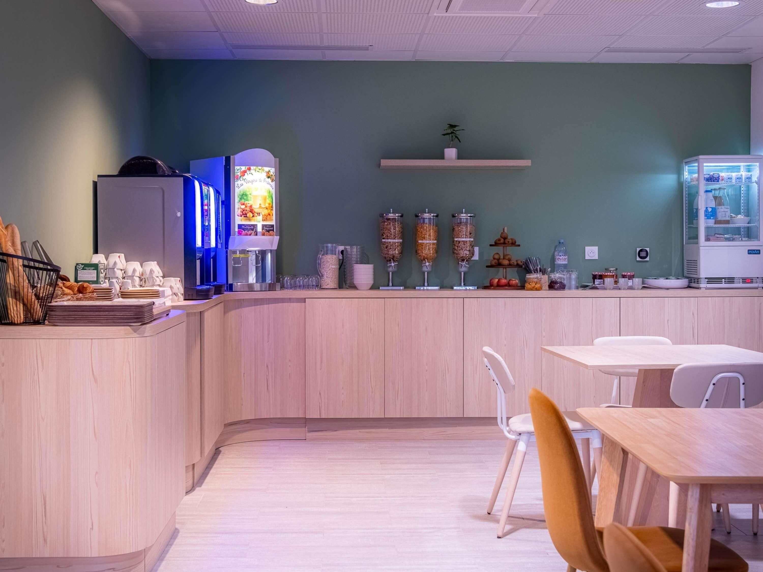 A cafe interior with a counter, seating area, and a coffee machine.