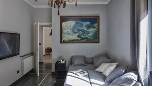 Una sala de estar moderna con un cuadro grande, un sofá y una araña.
