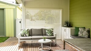 A patio with a white sofa, a round table, and a bench. - Golden Sands - Pet Friendly - 2 Mins Walk to Beach (Culburra Beach)