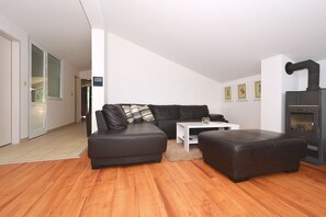 A modern living room with a black leather sofa, a white coffee table, and a fireplace. - Blue Sky 5 - apt with 3 bedrooms for 5+2 in Mastrinka, (Mastrinka)