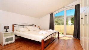 Ein Schlafzimmer mit einem Bett, Nachttischen und Blick ins Freie.