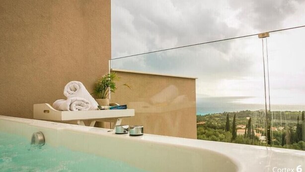 A spa area with a bathtub, towels, and a potted plant.