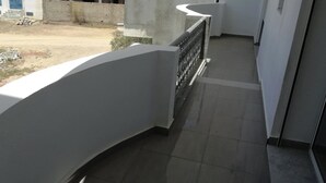 A corridor with a tiled floor, white walls, and a curved balcony railing. - 1 km From Mansoura Kélibia Beach (Kelibia)