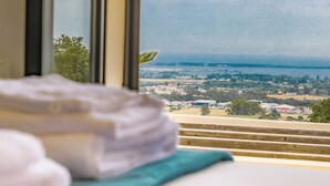 A bed with a view of a landscape through a window. - Villa with pool, sea view (Borgo)