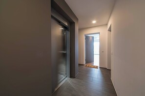 A hallway with a sliding door, a rug, and a door leading to a bright room. - Vacation Rental City 10 in Massagno (Massagno)