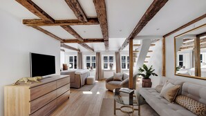 Un salon moderne avec des poutres apparentes, un grand téléviseur à écran plat, un canapé, une table basse et une plante en pot.