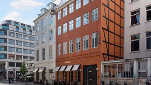 A multi-story building with a cafe on the ground floor, large windows, and a modern architectural style. - Regent 2- Endearing 1-bdr Apt in Centre of Copenhagen (Copenhagen)