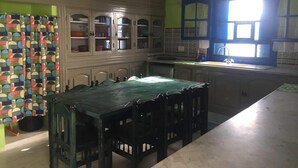 A kitchen with a dining table, cabinets, and a window.