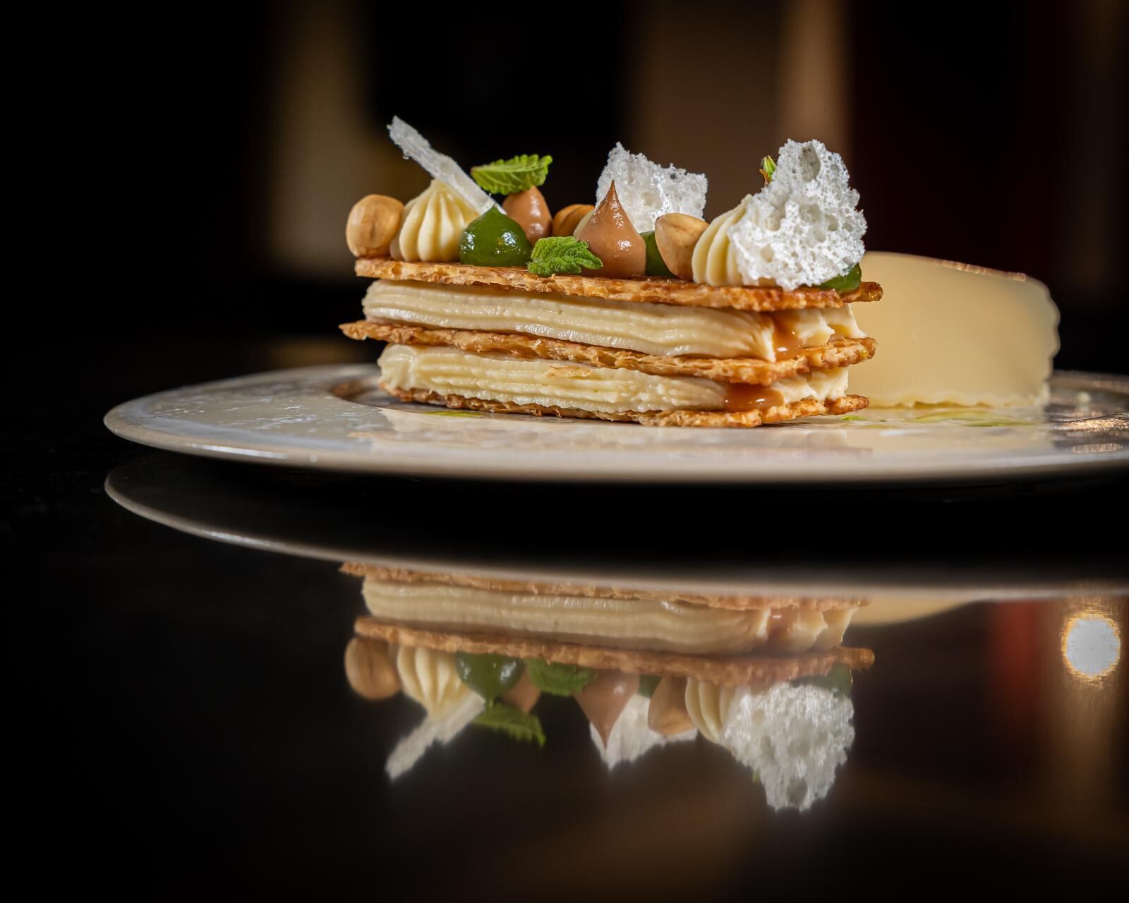 A dessert on a plate with a reflective surface.