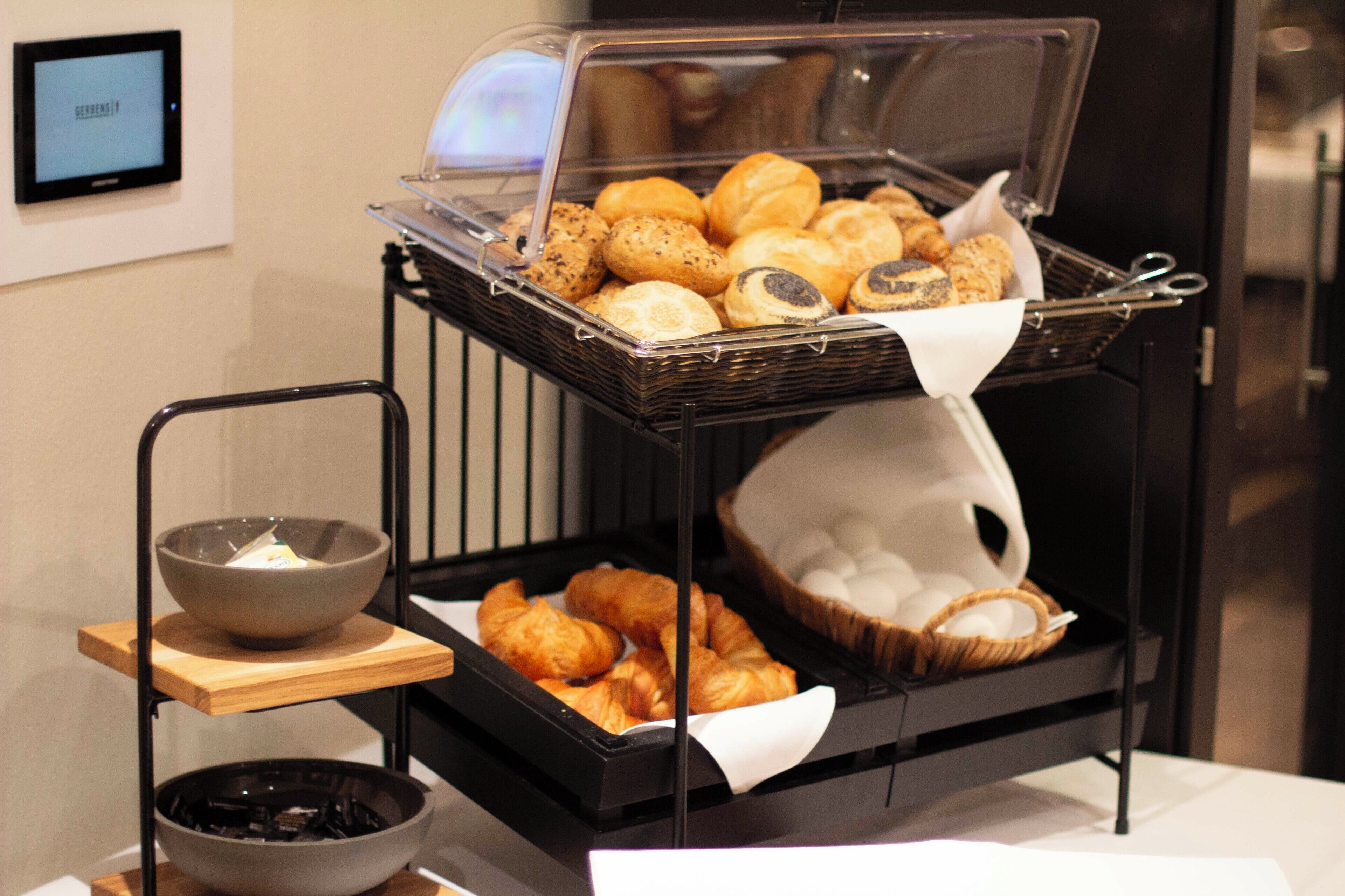 A buffet with various baked goods and a bowl of soup.