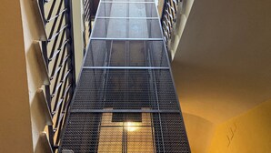 A multi-level atrium with a central staircase surrounded by metal railings. - Bright apartment near Villa Borghese (Roma)