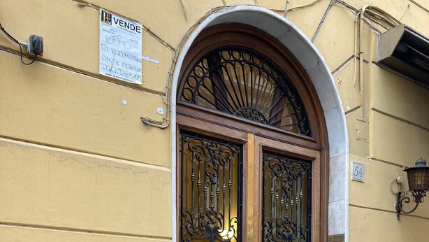 A yellow building with a large, ornate metal gate and a wooden door. - Bright apartment near Villa Borghese (Roma)