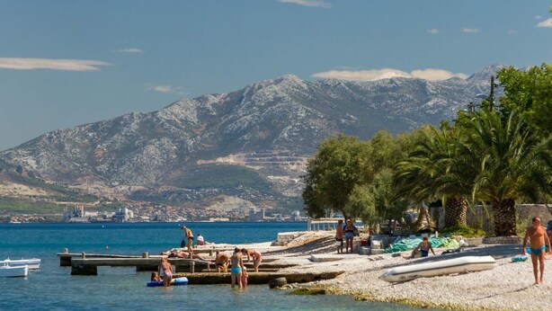 A beach with a rocky mountain backdrop, a pier with people, and a clear sky. - MARIC 1 apt for 4+2, only 40 m from the beach in Mastrinka (Mastrinka)