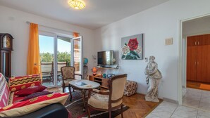 A living room with a sofa, chairs, a coffee table, a TV, and a statue. - MARIC 1 apt for 4+2, only 40 m from the beach in Mastrinka (Mastrinka)