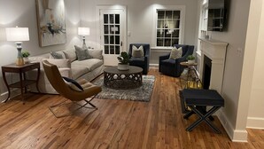 A living room with a sofa, two armchairs, a coffee table, and a fireplace.