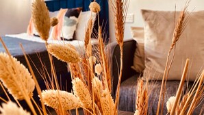 A close-up of wheat stalks in a room with a blue headboard and a bed with pillows. - Phaedrus Living Seaside Luxury Flat Athina 118 (Paphos)