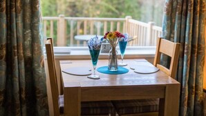 Ein Holztisch mit drei Blumenvasen und einer Glasflasche.