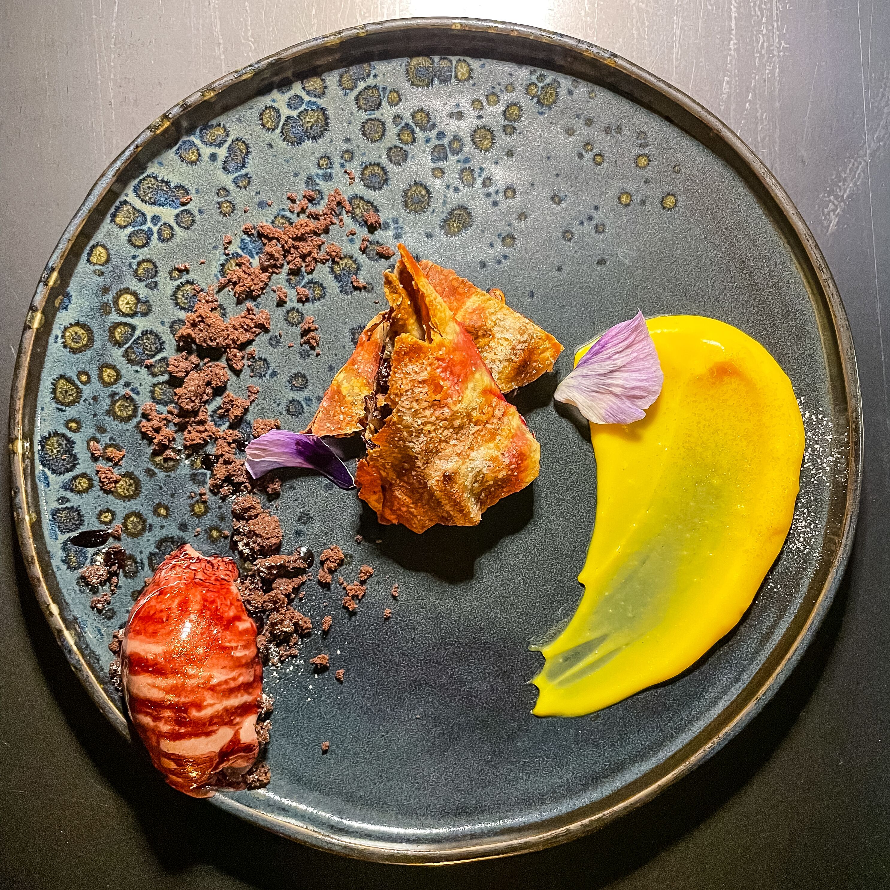 A plate with various food items and a yellow sauce.