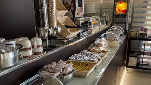 Zona de bufé con diversos alimentos, como pasta, pan y salsas.
