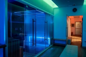 A modern hotel room with a glass partition, a wooden bench, and a clock on the wall. - Hotel & Spa Villa dei Mosaici (Spello)