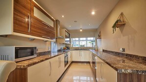 Una cocina moderna con una isla central, armarios blancos y un microondas.