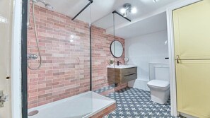 A bathroom with a glass-enclosed shower, a white sink, a toilet, and a mirror. - Host & Stay | The Burrow (Alnwick)