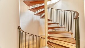 A spiral staircase with wooden steps and metal railings. - Host & Stay | The Burrow (Alnwick)