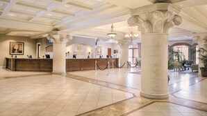 A spacious lobby with a reception desk, large columns, and a chandelier. - 2 BR -Bonnet Creek Pools, Dining, Pirate Ship Slide, Mini Golf (Lake Buena Vista)