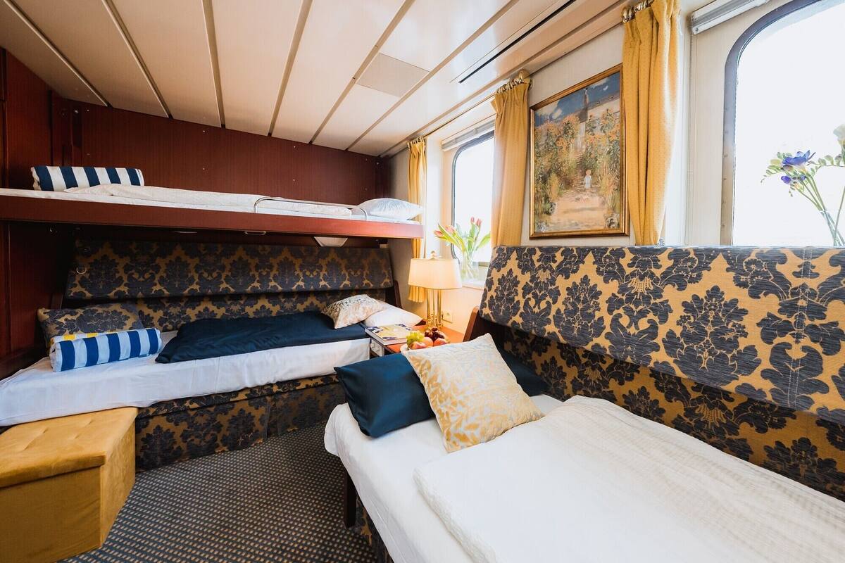 A compact cabin with bunk beds, a small table, and a lamp.