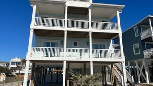 A multi-story building with balconies, a visible address number, and a clear sky. - 1030 Ocean 5 Bedroom Home by RedAwning (Supply)
